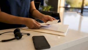 Clinic receptionist organizing patient appointment cards