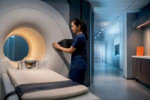 Radiologic technologist beside MRI scanner