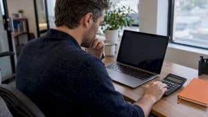 Agent comparing advertising costs at worktable